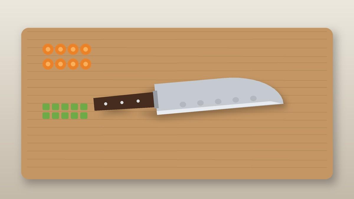 Santoku knife with a hollow edge beside sliced carrots and diced vegetables