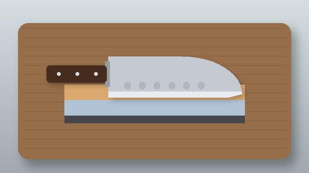 Santoku knife with a hollow edge resting on a two-sided whetstone